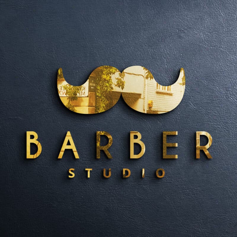 Witraż z motywem wąsów i napisem BARBER STUDIO na ciemnym tle.