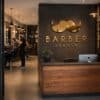 Nowoczesny wystrój salonu barberskiego z logo w stylu wąsów na ścianie.